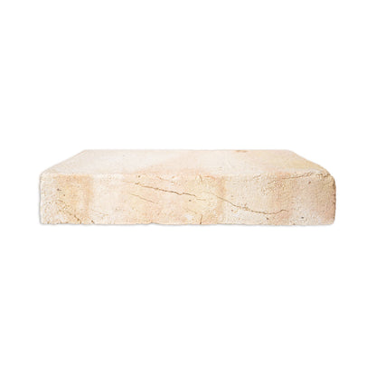 A rectangular stone tile or brick sample with a textured, light beige surface and natural-looking cracks, shown against a plain white background.