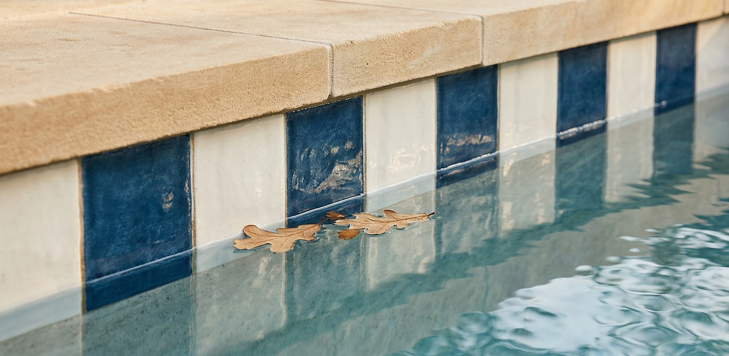 Champagne 6x6 glazed cotto pool waterline tile by Clay Imports, shown in a checkerboard pattern with blue tiles, light coping, and leaves.