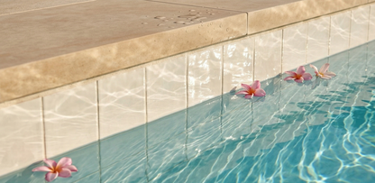 Glazed Cotto Champagne 6x6 Pool Waterline Tile by Clay Imports, installed at a pool's edge with floating pink flowers.
