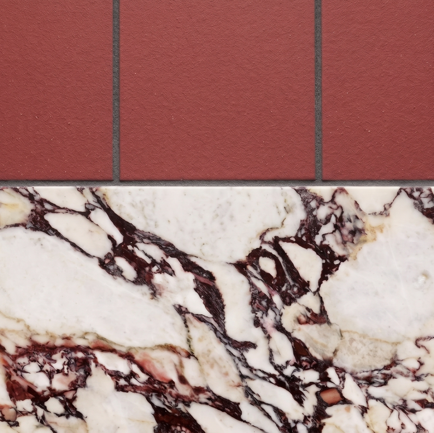 Wild Berry clay tiles by Clay Imports, reddish-brown and textured, above white marble with deep red veins.