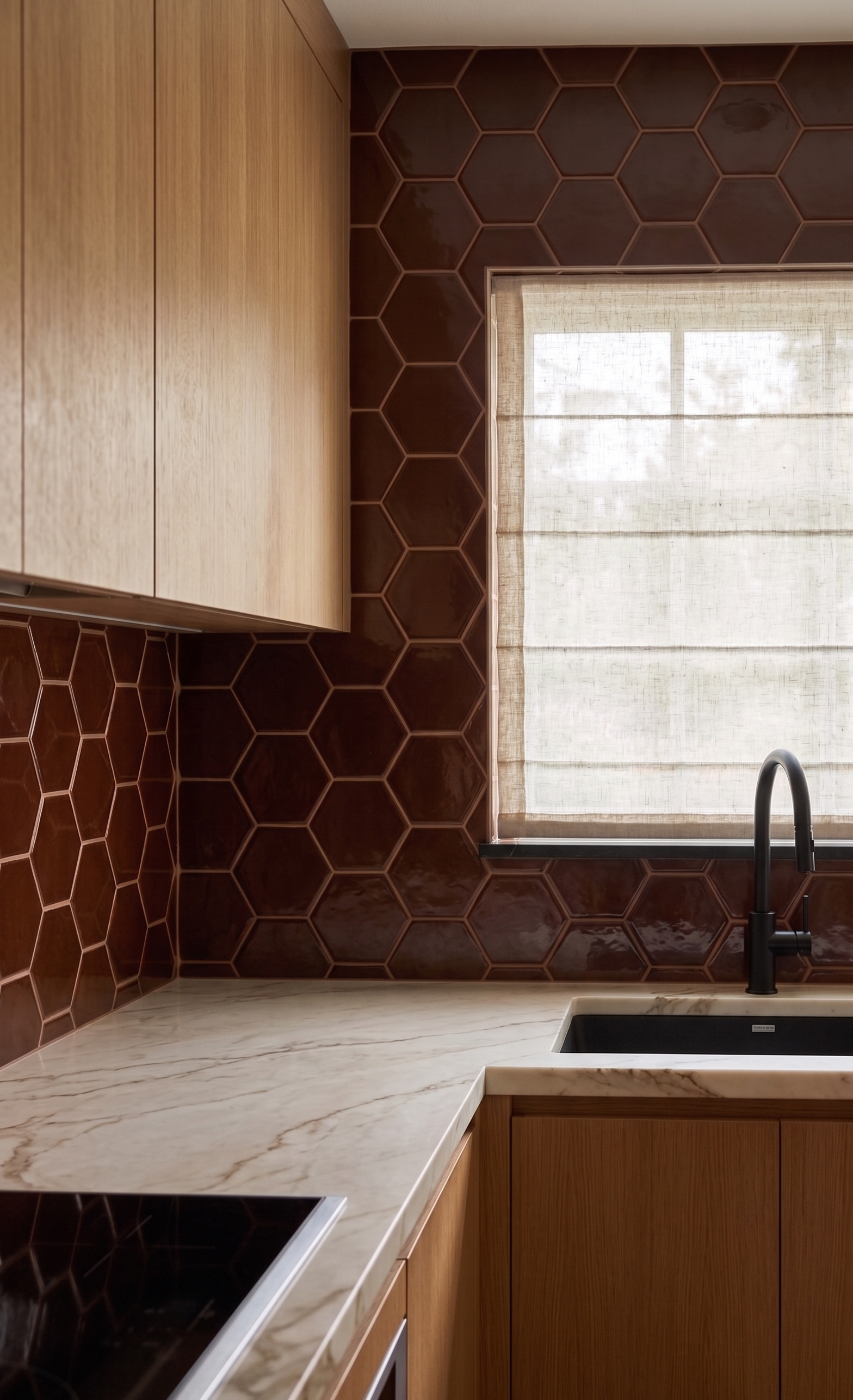 Hexagonal oxblood clay tiles by Clay Imports, featuring a glossy finish as a kitchen backsplash with marble countertop and wood cabinets.