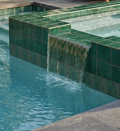 Green ceramic pool waterline tile by Clay Imports Handmade Tile, featuring square and fan-patterned tiles with a waterfall.