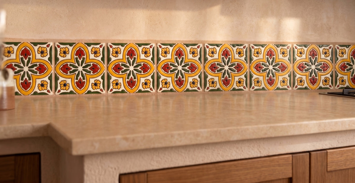 Vibrant Spanish tiles with red, yellow, and green floral patterns line the kitchen backsplash above a polished beige countertop.