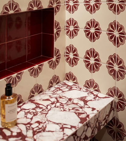 Marble-patterned shelf against a tiled wall with floral designs