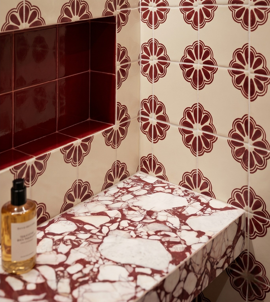 Marble-patterned shelf against a tiled wall with floral designs