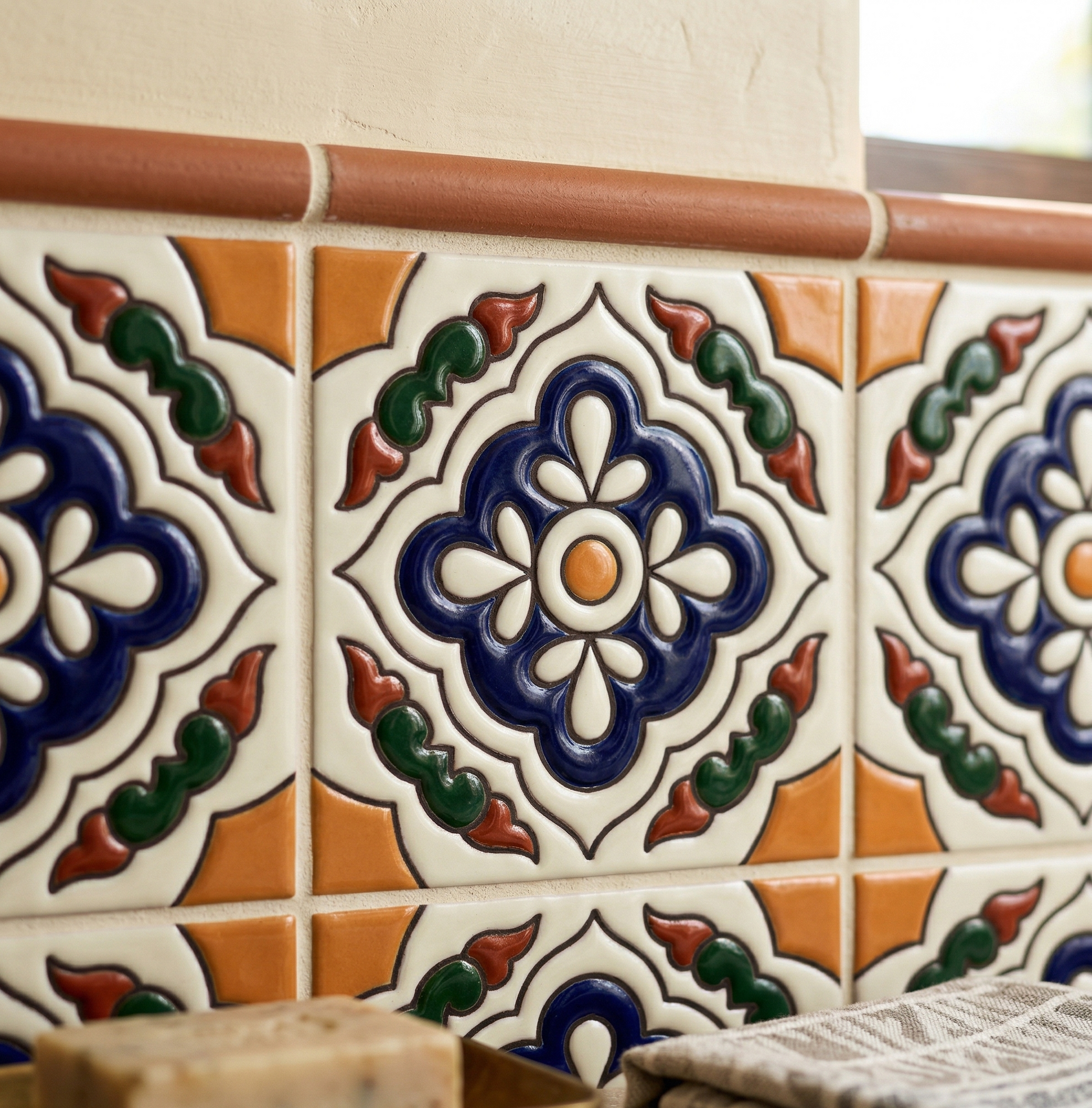 Relief Petunia Talavera ceramic tile by Clay Imports, featuring a stylized blue, white, orange, green, and red floral pattern.