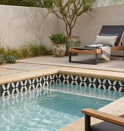 Deep Black Cruces pool waterline tile by Clay Imports, featuring a black and white geometric pattern installed around a light blue pool.