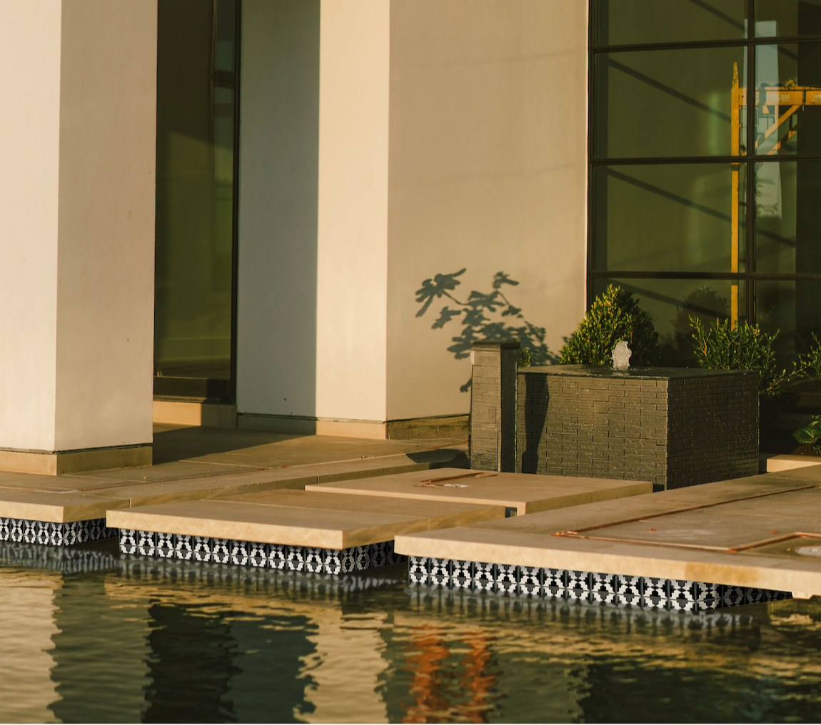Black and white patterned pool waterline tile by Clay Imports, featuring a Cruces design along a pool edge.