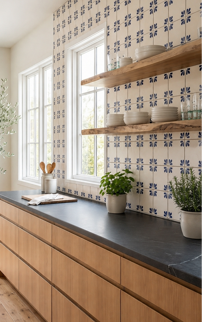 Cream and navy blue floral-patterned 6x6 Talavera tile by Tula, installed as kitchen backsplash with wooden shelves and greenery.