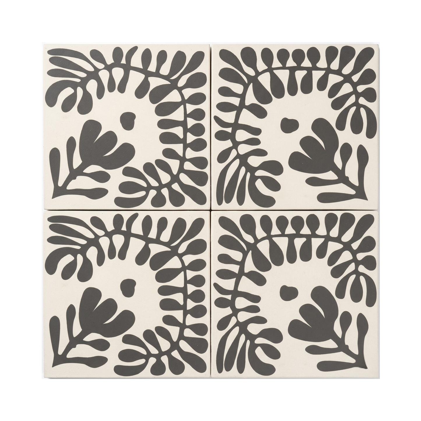 Pitch black Sprig Vocho pattern tile by Clay Imports, featuring a stylized botanical leaf design on a cream background.