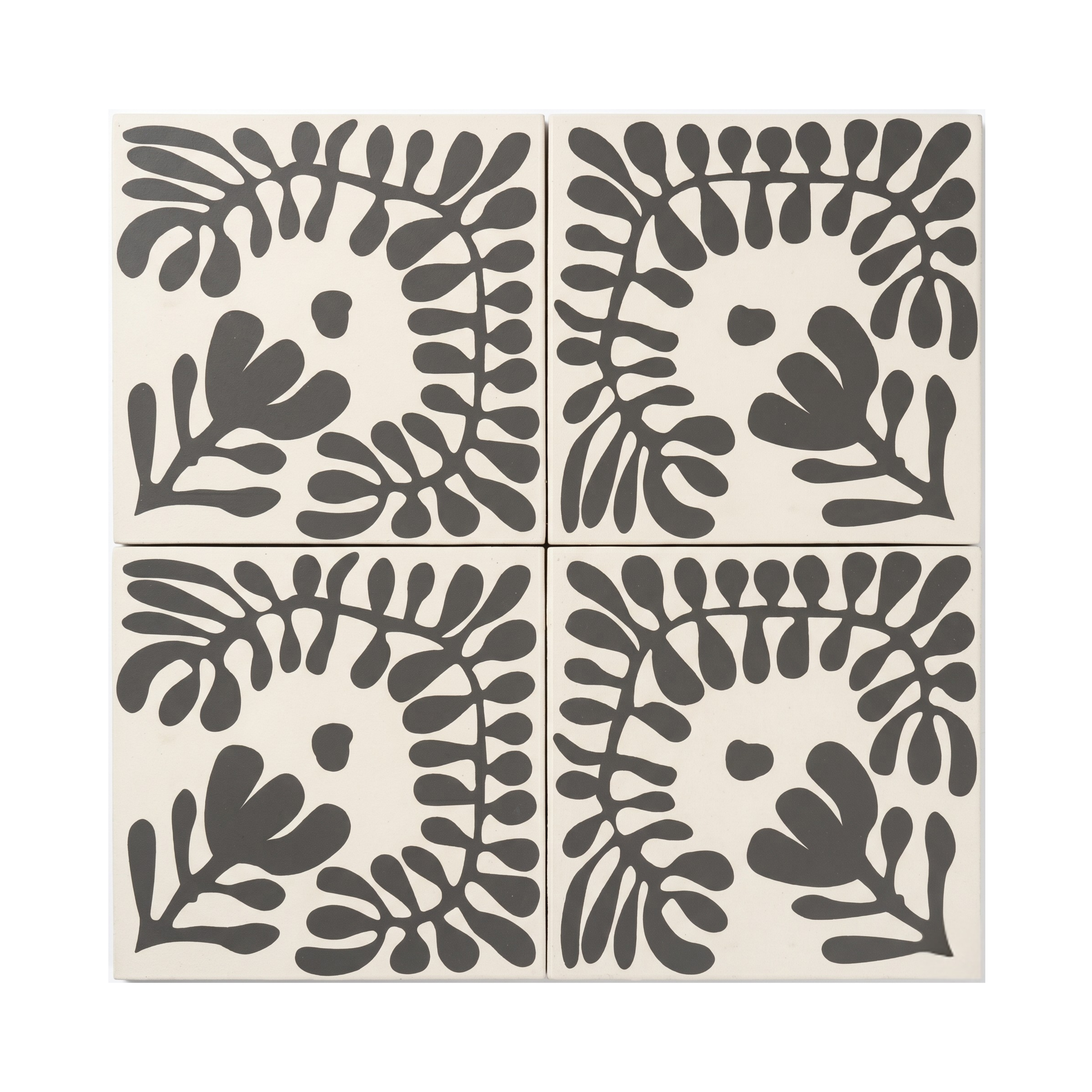 Pitch black Sprig Vocho pattern tile by Clay Imports, featuring a stylized botanical leaf design on a cream background.