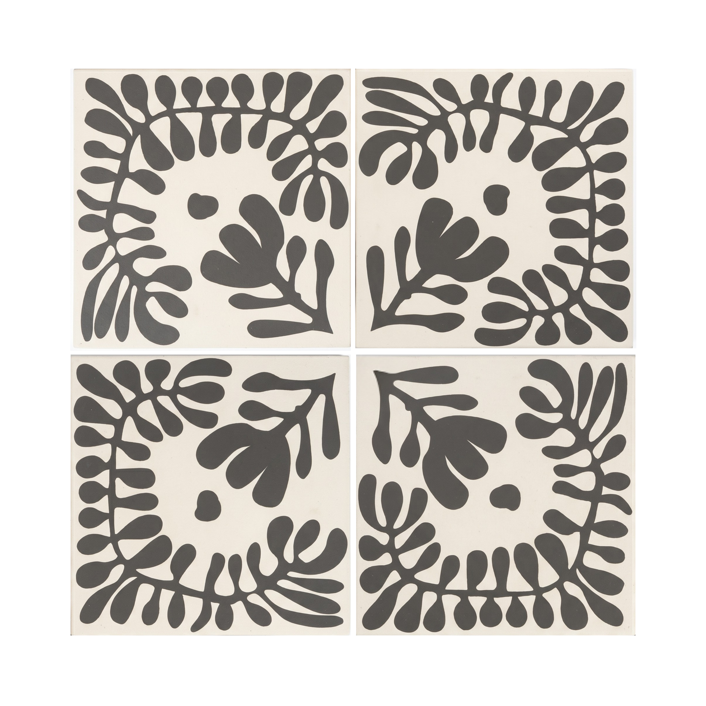 Four Pitch Black Sprig Vocho pattern tiles by Clay Imports, showing stylized organic leaves on an off-white background.