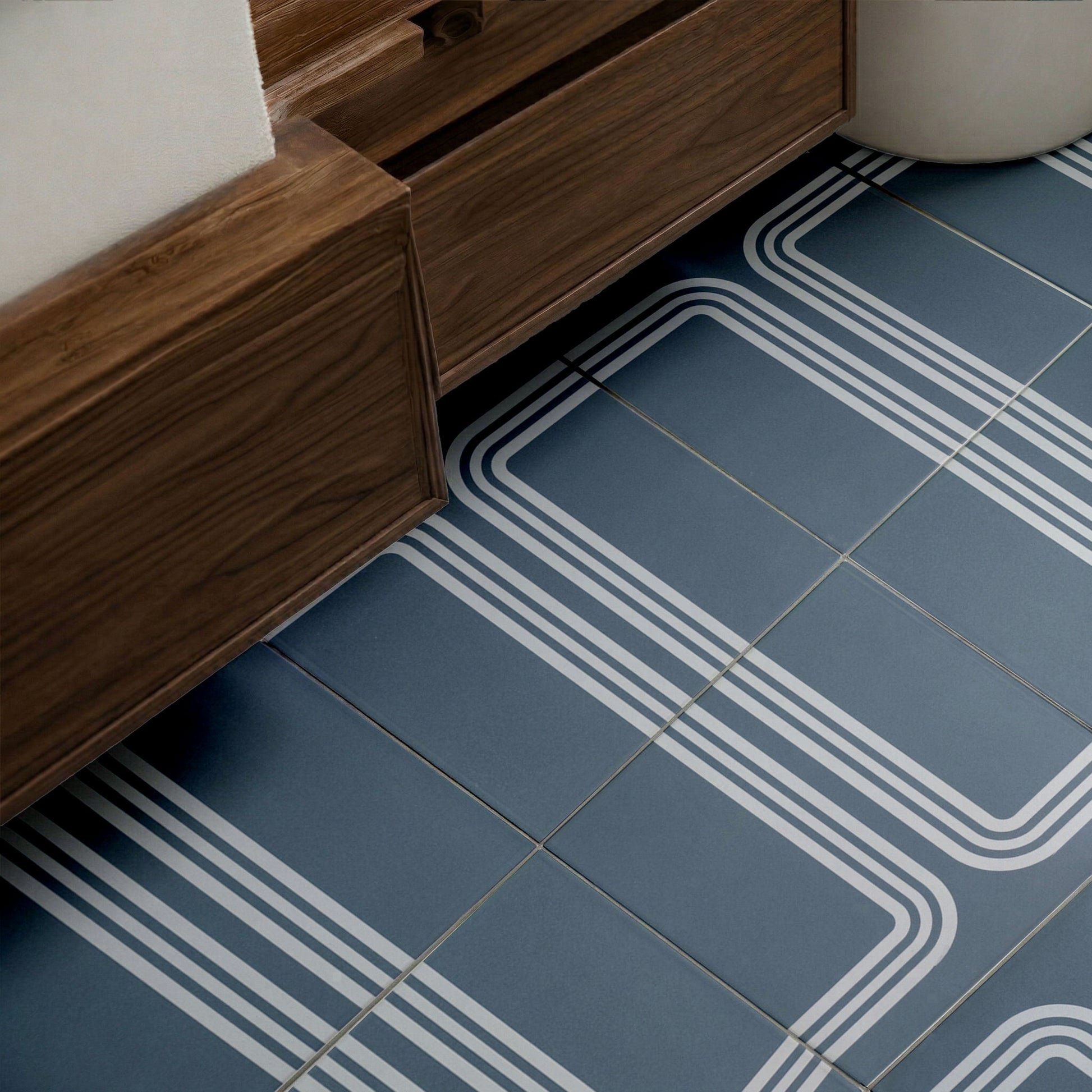 Midnight blue 8x8 pattern tile by Clay Imports with white triple-line geometric patterns on a floor next to dark wood.