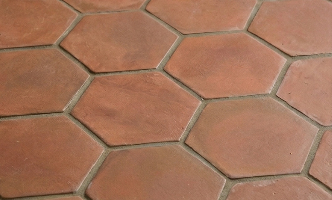 Umber Hexagon Cotto tiles by Clay Imports with a rustic, matte surface and light gray grout.