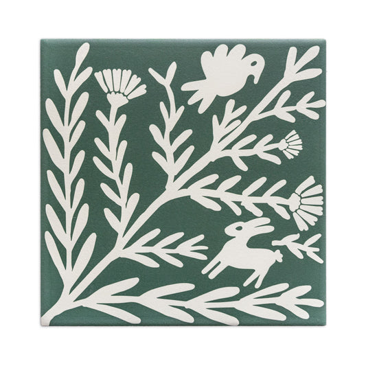 Dark green sample tile by Clay Imports featuring an off-white folk art design of flowers, leaves, a bird, and a rabbit.