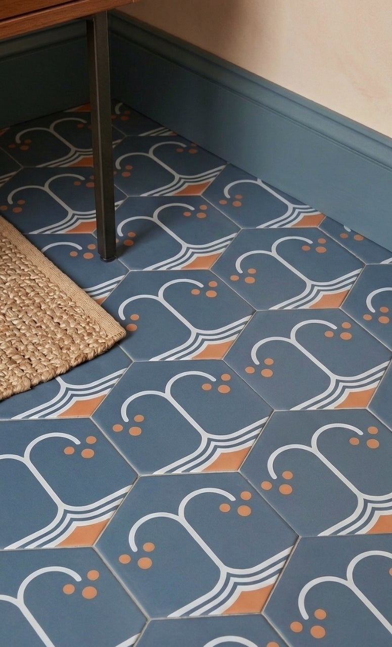 Midnight blue hexagonal pattern tile by Clay Imports, with white wave designs, orange accents, and small dots on a floor.