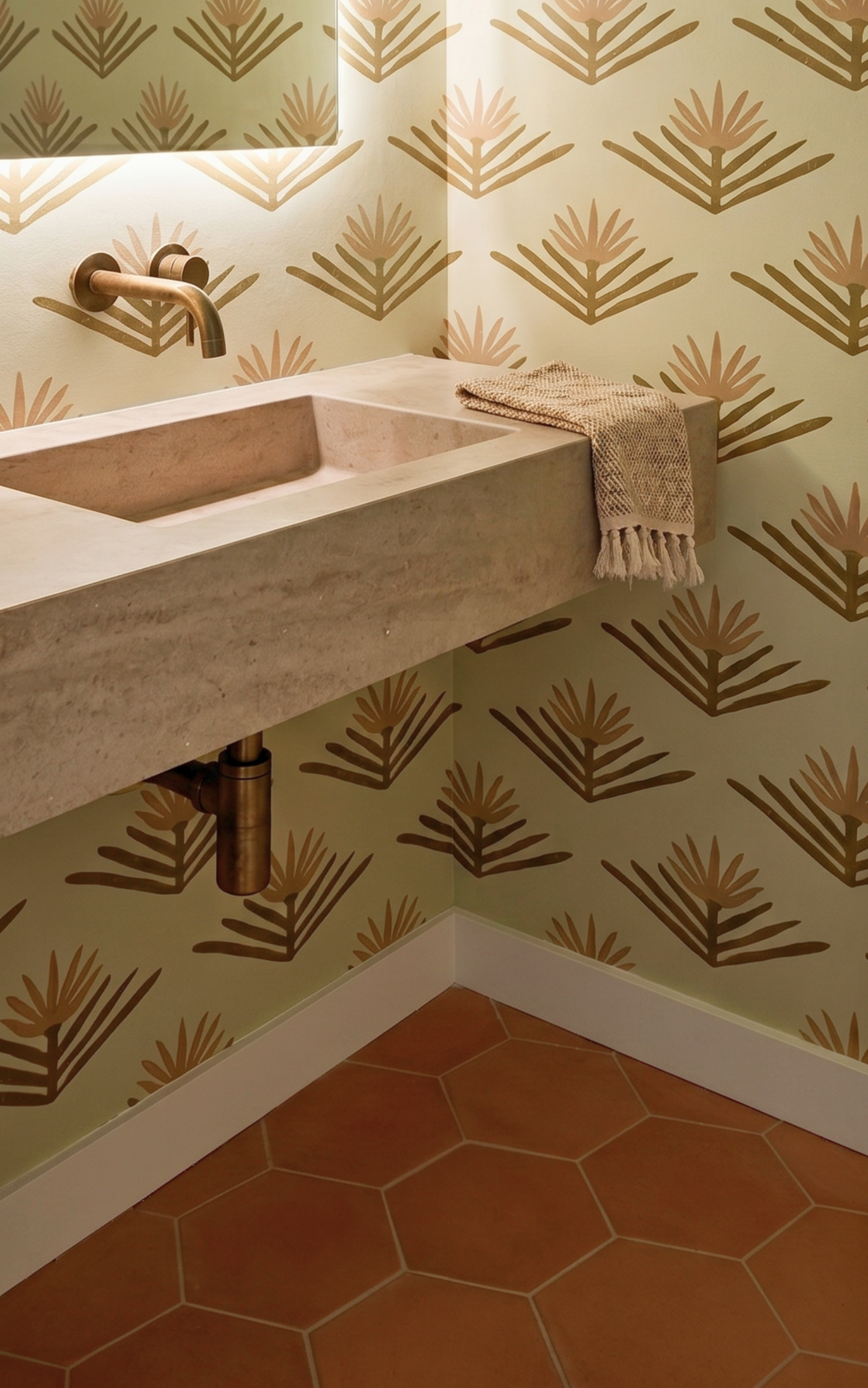 Bathroom corner with a concrete sink against a patterned wall.
