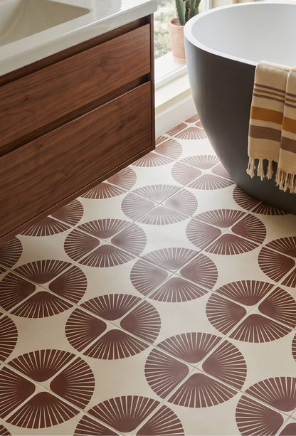Bathroom with wooden vanity, white bathtub, and patterned floor tiles.