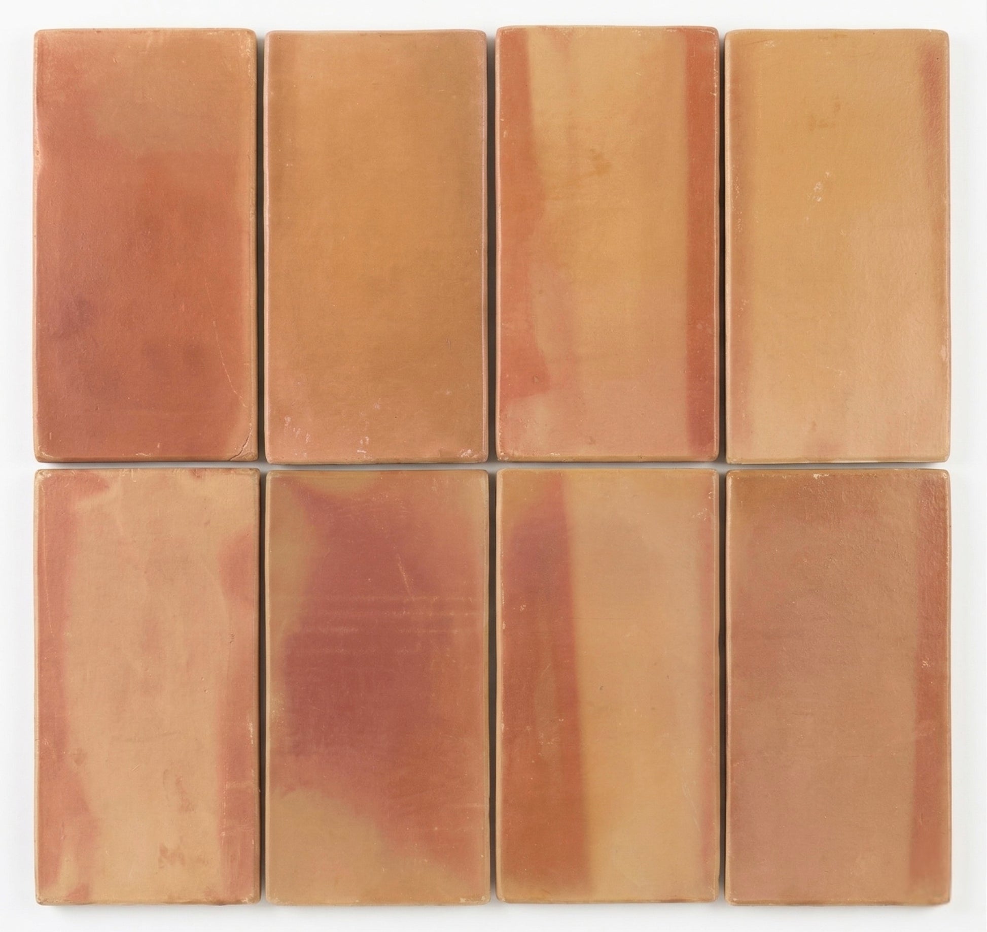 Eight rounded terracotta tiles by Clay Imports, showing varied reddish-orange and earthy brown hues.