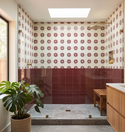 Oxblood 8x8 glossy clay tile from Clay Imports installed on lower shower walls, beneath white floral tiles.