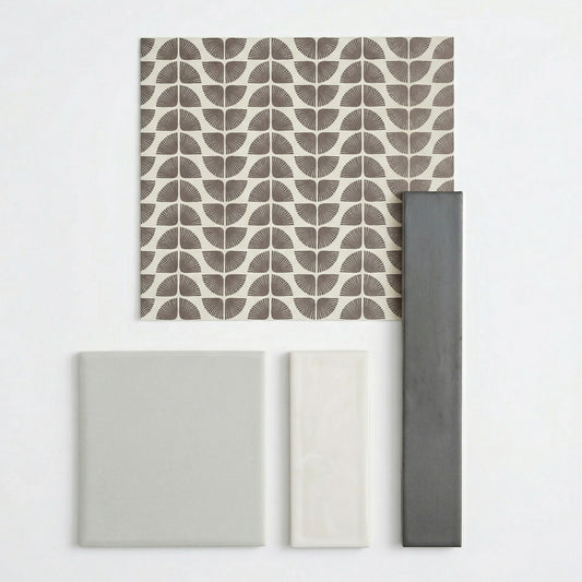 Assorted tile samples by Clay Imports, including dark grey, light grey, off-white, and a brown fan-patterned tile.