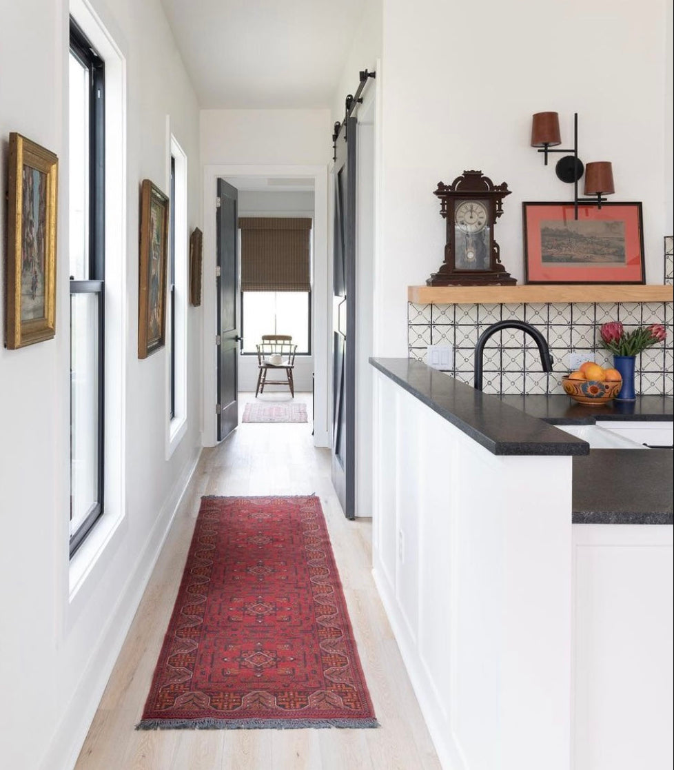 Hand-painted black and white geometric tile backsplash by Clay Imports, featuring a repeating grid pattern in a modern kitchen.