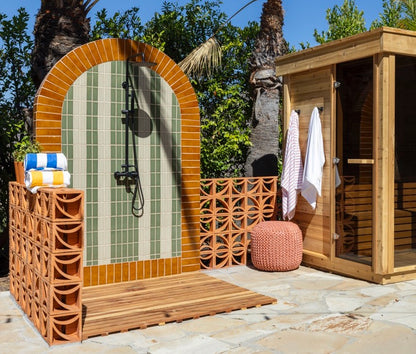 Terra Crackle Glazed Thin Brick by Clay Imports forming an outdoor shower arch and decorative side wall.