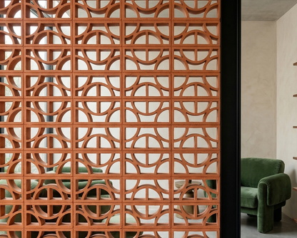 Terracotta breeze block from Clay Imports Breeze Blocks featuring a geometric pattern of semicircles, creating a decorative room divider.