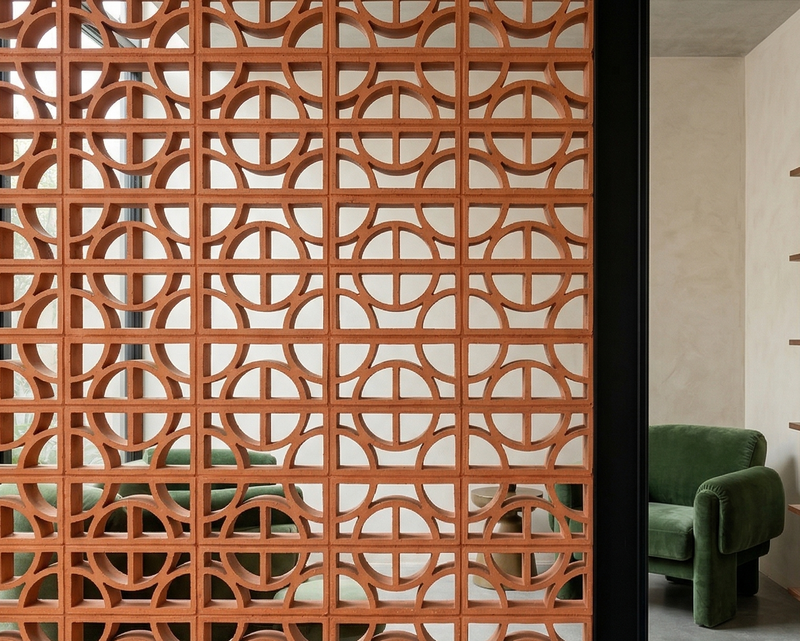 Terracotta breeze block from Clay Imports Breeze Blocks featuring a geometric pattern of semicircles, creating a decorative room divider.