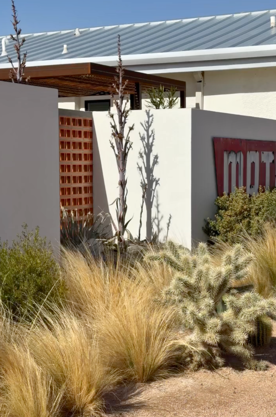 Terracotta breeze block with a rectangular grid pattern by Clay Imports Breeze Blocks, forming a decorative vent screen in a modern desert garden.