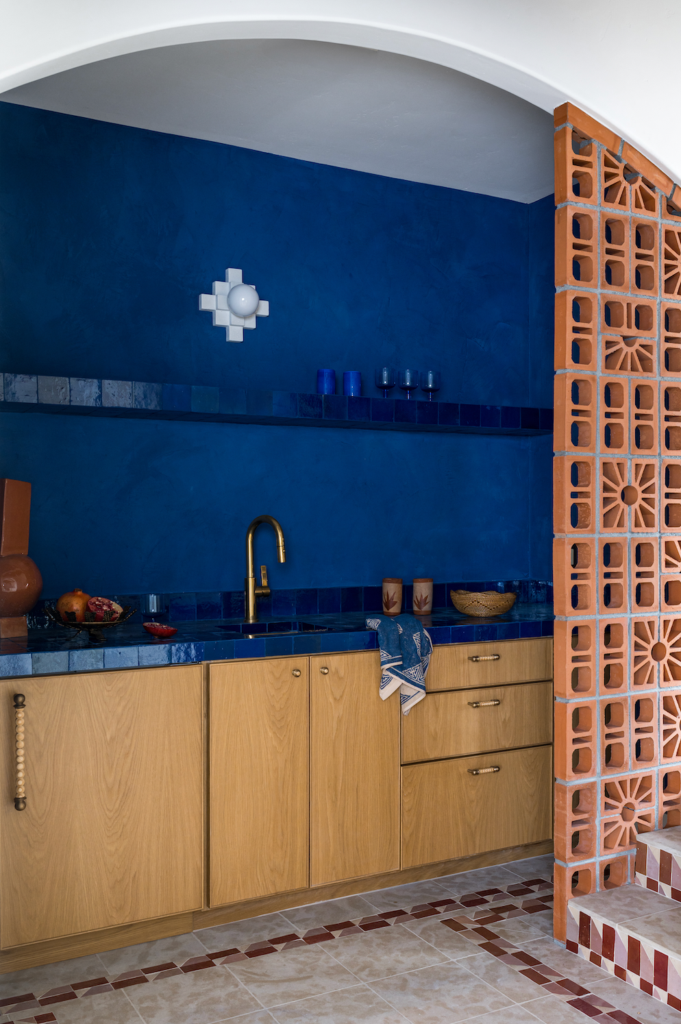Terracotta Petalo Breeze Block by Clay Imports, featuring intricate sunburst and geometric patterns, forming an arched room divider.