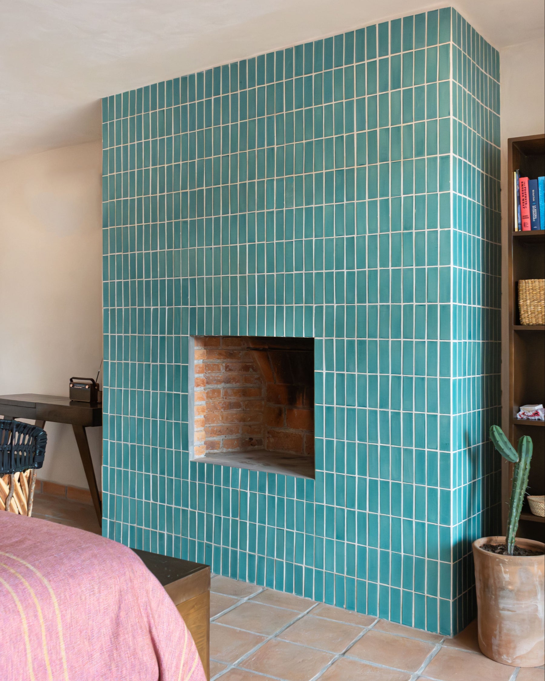 Teal rectangular Costa 2x6 solid tiles by Clay Imports, installed vertically covering a modern fireplace with bright grout.