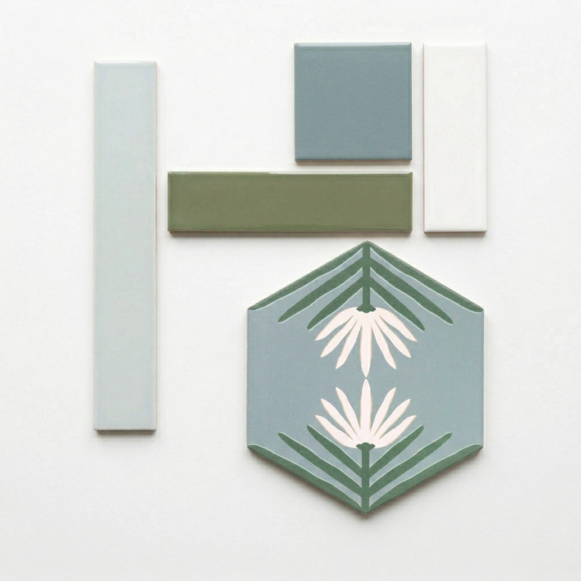 Desert Morning tile samples by Clay Imports, in light blue, sage green, and white, with a hexagonal floral tile.