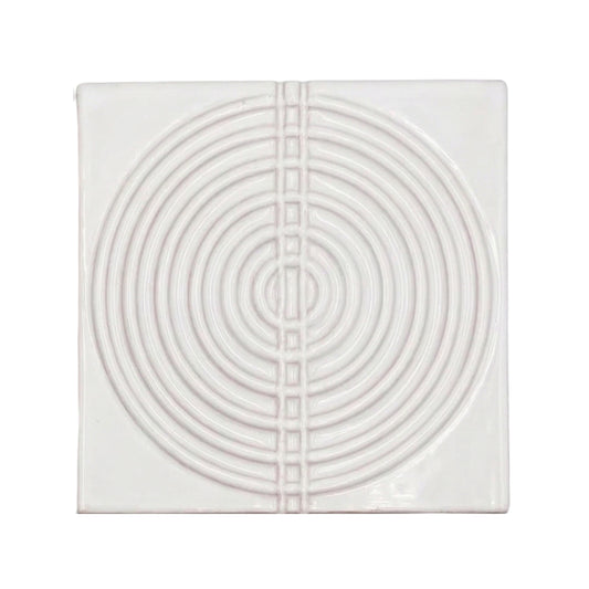 Square sample tile in Dusk Perla gloss finish by Clay Imports, with a raised pattern of concentric circles bisected by squares.