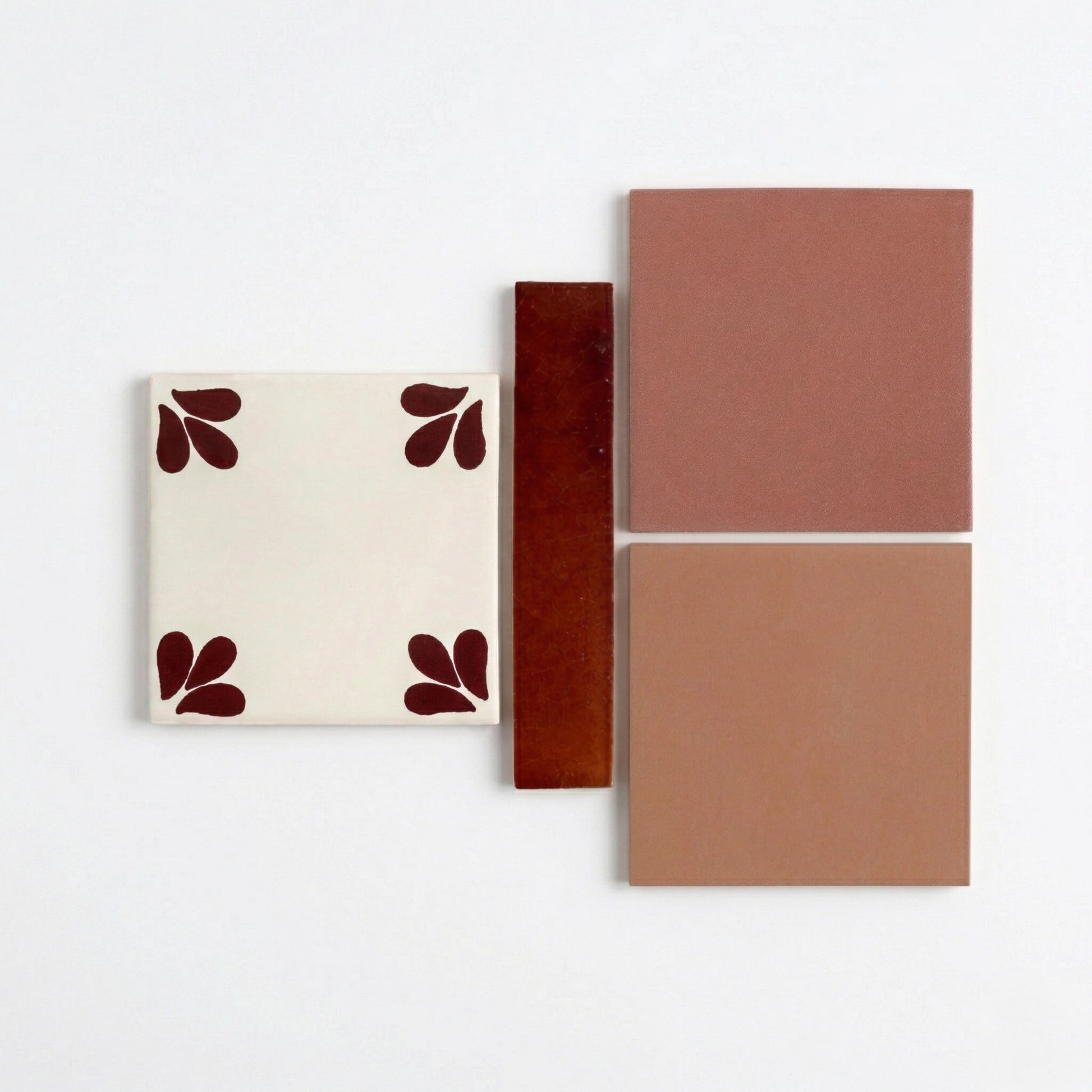 Assortment of ceramic tile samples by Clay Imports, including patterned cream, glossy reddish-brown, and matte terracotta squares.
