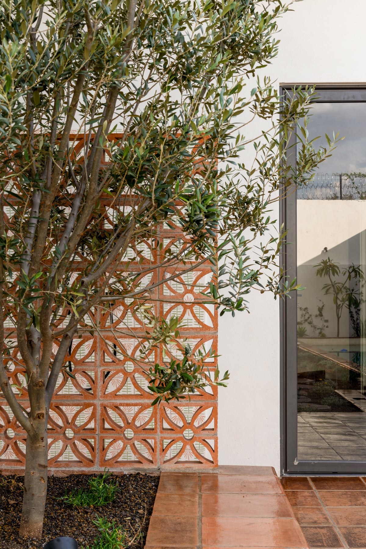 Terracotta Breeze Block Dulce by Clay Imports Breeze Blocks featuring a geometric floral pattern in an outdoor wall.