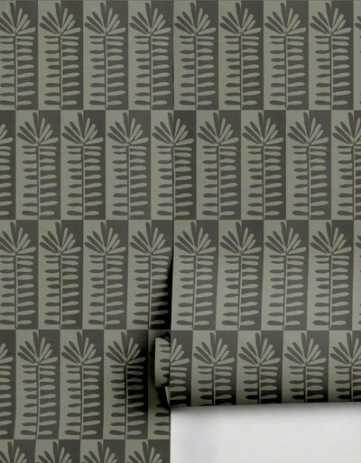 Muted olive green and dark grey wallpaper by Clay Imports, featuring a repeating stylized leaf pattern, with a partial roll visible.