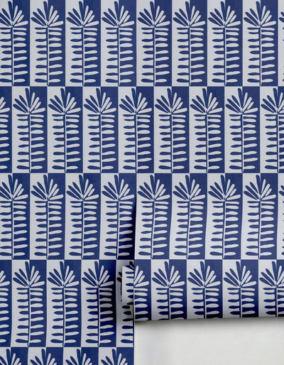 Navy blue and white Florería Wallpaper by Clay Imports with a repeating botanical pattern, partially unrolled.