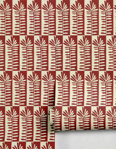 Red and cream patterned wallpaper by Clay Imports featuring stylized leaf motifs and a checkerboard base, partially unrolled.