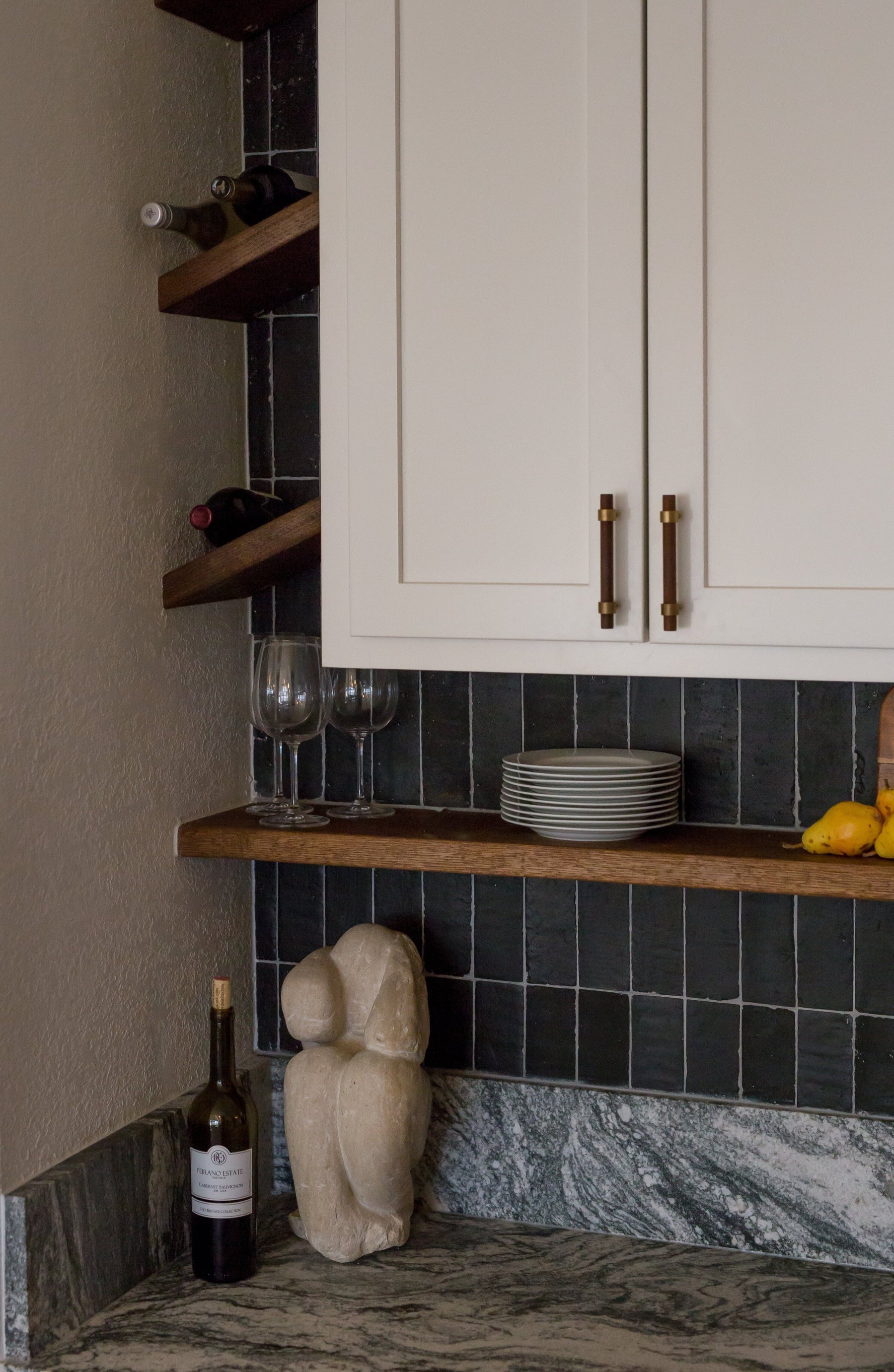 Black Suede Glazed Thin Brick by Clay Imports, installed vertically with visible white grout lines in a kitchen.