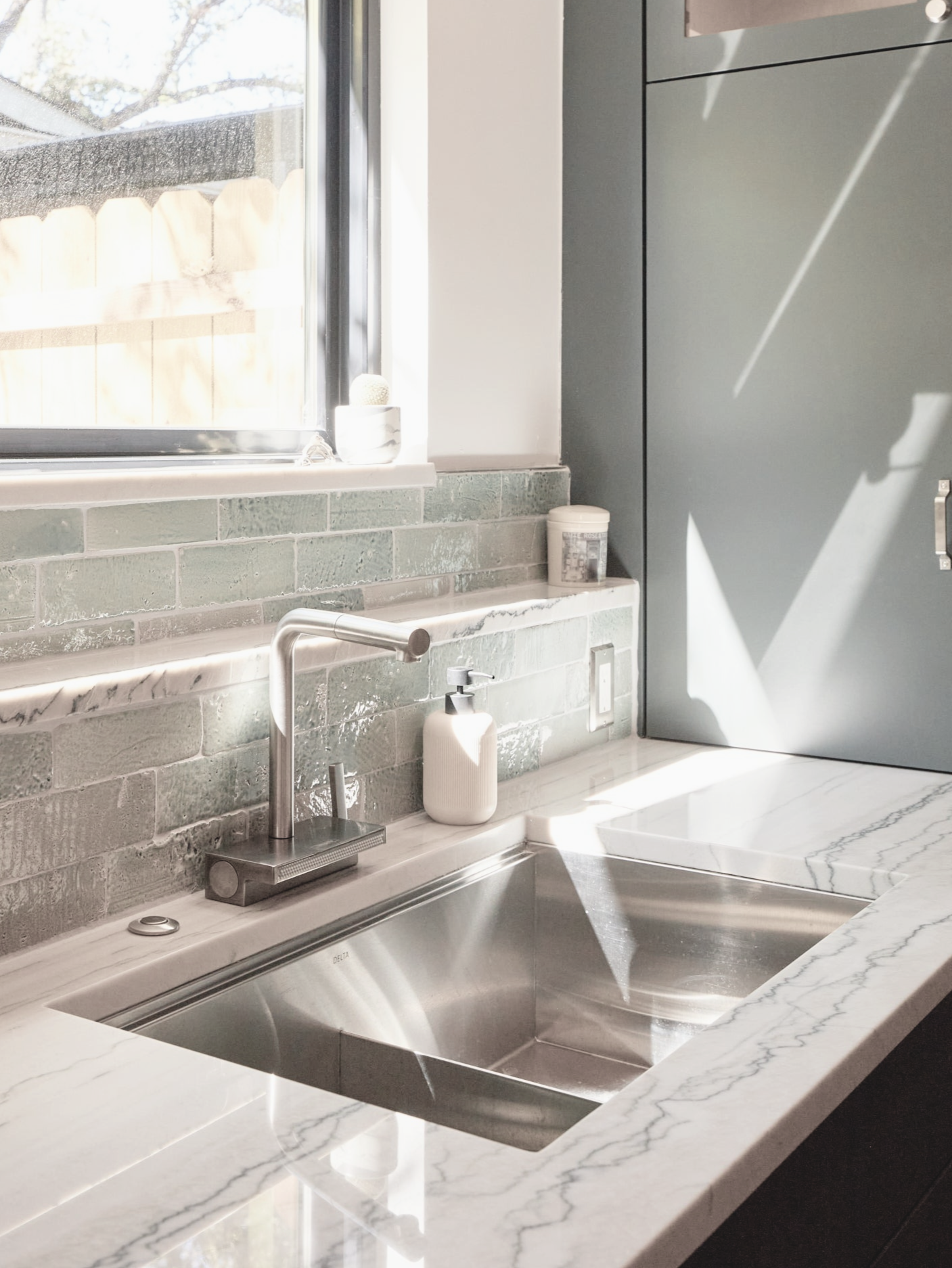 Glazed Thin Brick Glacier 2.5x8 by Clay Imports, forming a textured backsplash in a sunlit kitchen.