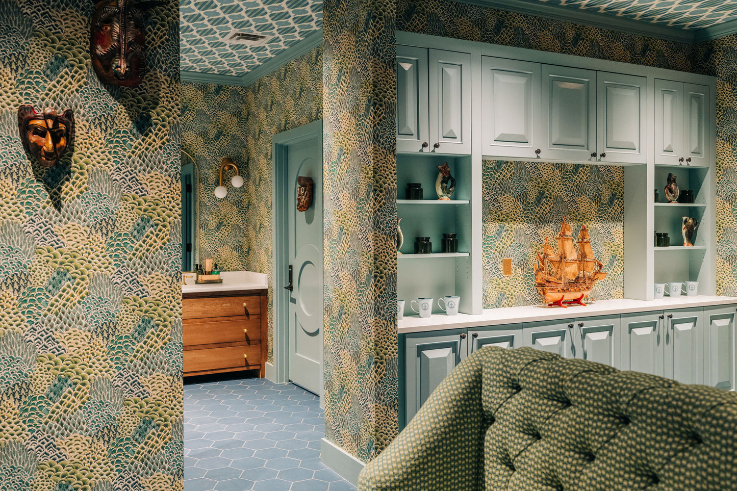 Light blue San Miguel hexagon clay tiles by Clay Imports on a floor in a colorful room with patterned wallpaper.