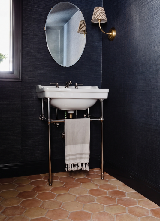 Hexagon smooth matte terracotta tiles from Clay Imports laid on a floor, showing natural reddish-brown variations and grout lines.