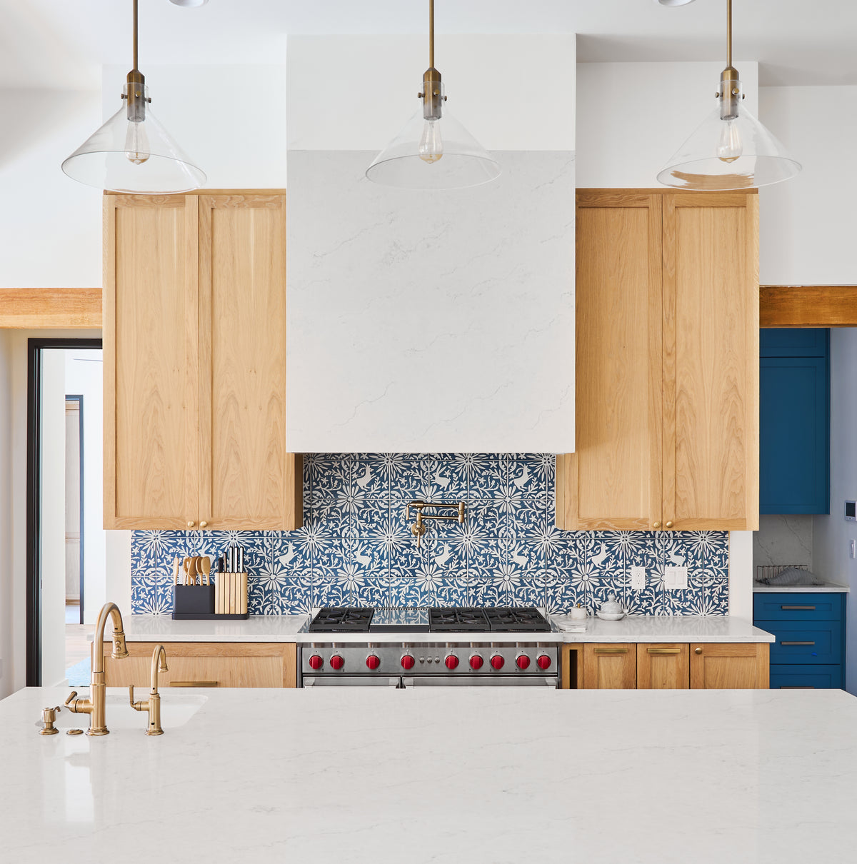 Blue and white patterned tile by Clay Imports featuring deer and floral motifs as a kitchen backsplash.