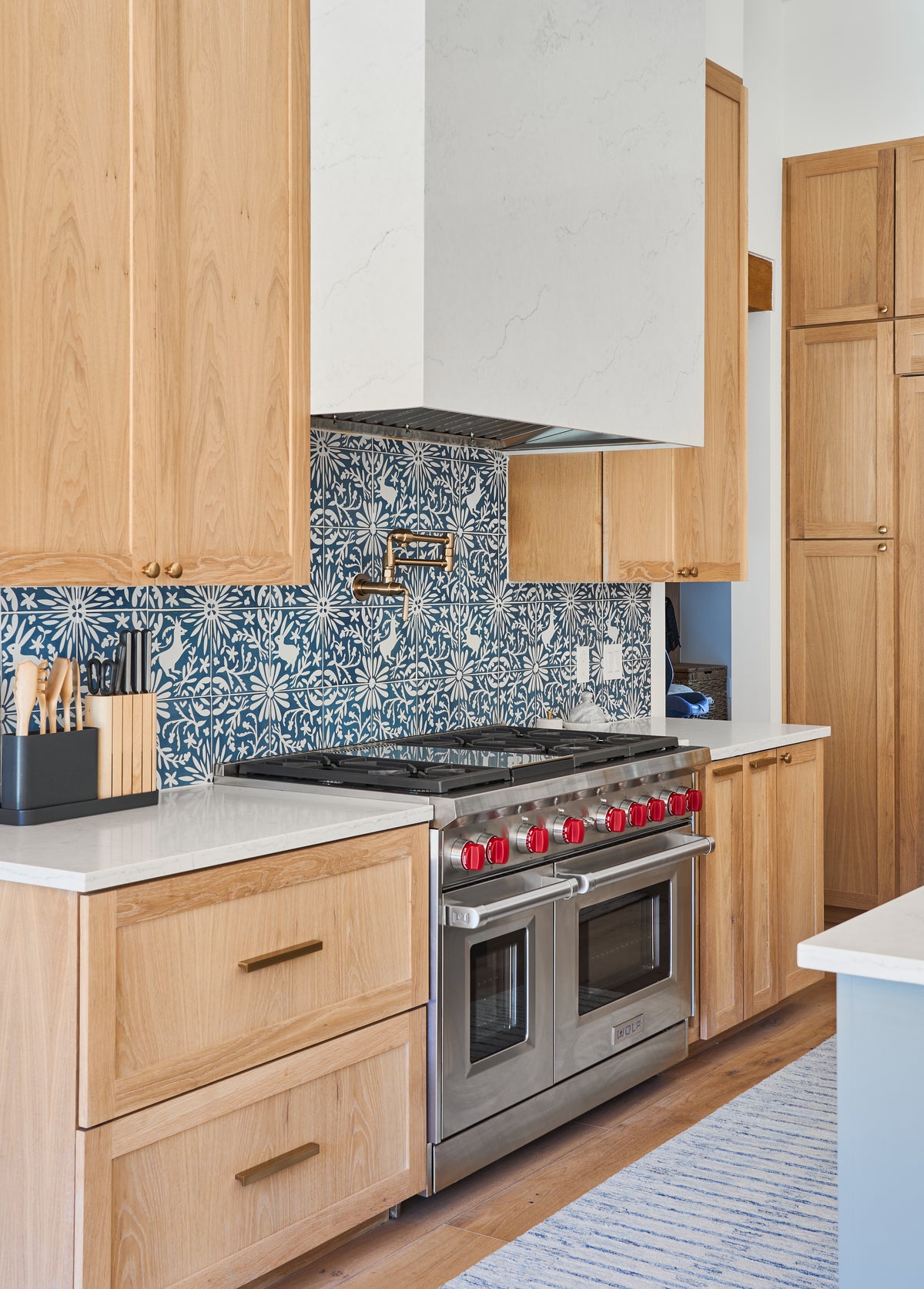 Midnight blue and white patterned tile by Clay Imports, featuring a distinctive floral and rabbit design as a kitchen backsplash.