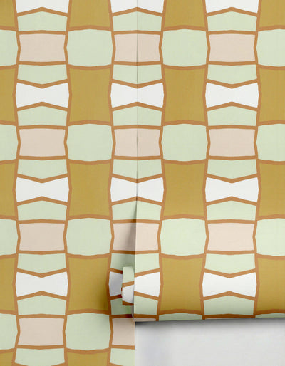 Wallpaper by Clay Imports with a geometric pattern of olive, light green, pink, and white blocks with organic brown outlines, partially unrolled.