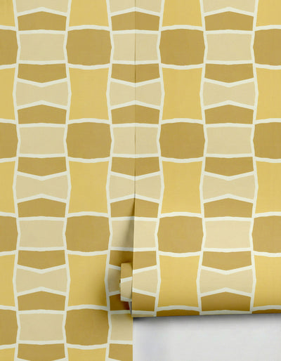Yellow and beige geometric wallpaper by Clay Imports, featuring an abstract interlocking pattern and shown partially unrolled.