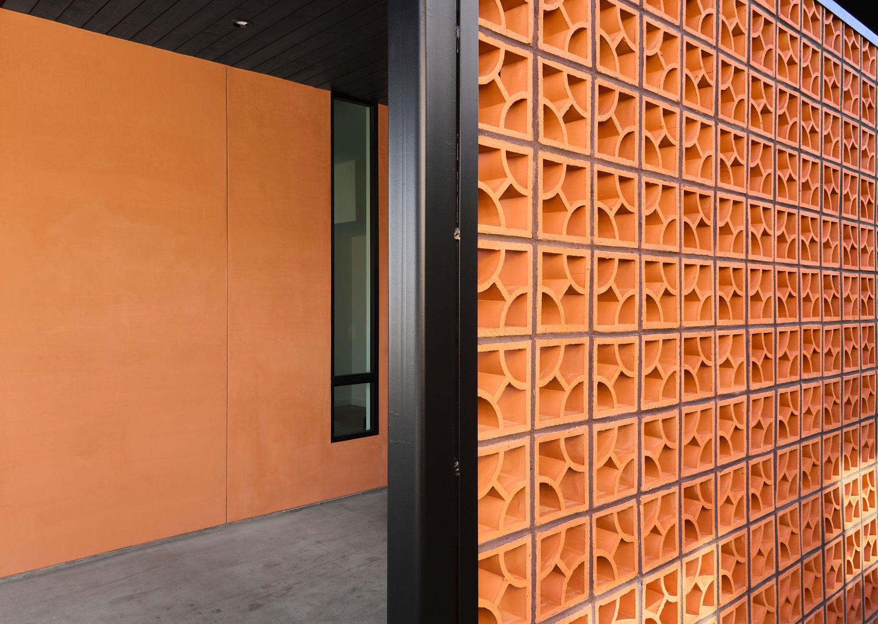 Lava orange breeze block from Clay Imports featuring a repeating pinwheel pattern on a full wall.
