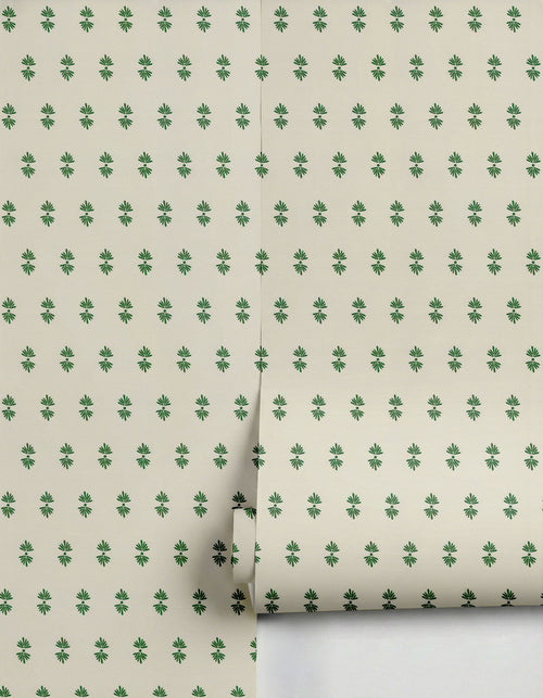Cream wallpaper by Clay Imports with a repeating pattern of small dark green stylized flowers, partially unrolled.