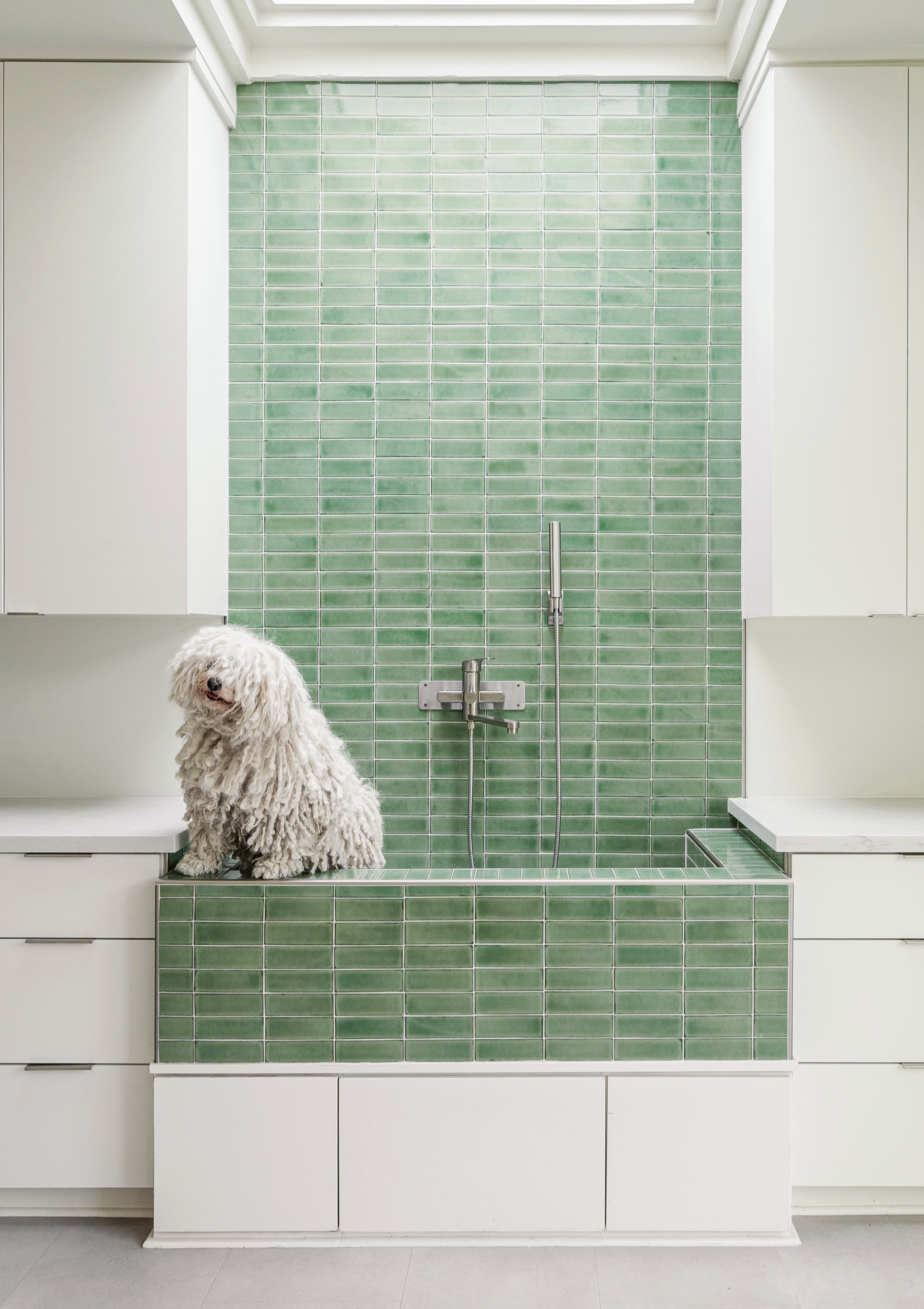 Aqua green 2x6 solid tile by Clay Imports, featuring a glossy finish installed on a bathroom wall and raised bath.